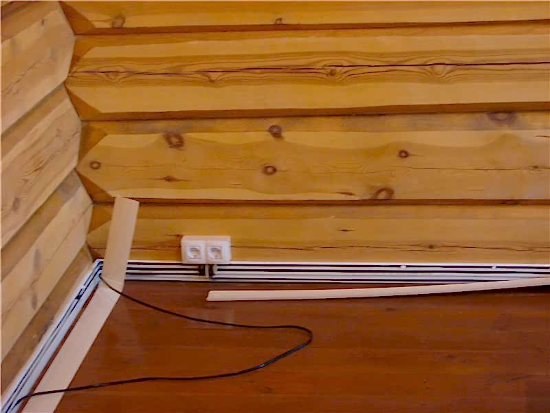 процесс монтажа плинтусных кабель-каналов в деревянном доме